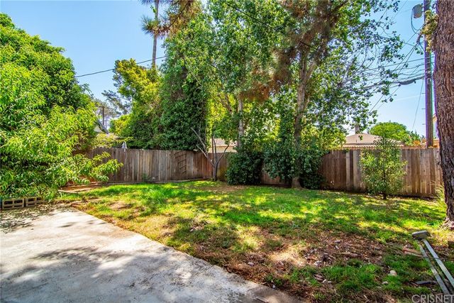 a green field with trees in the background