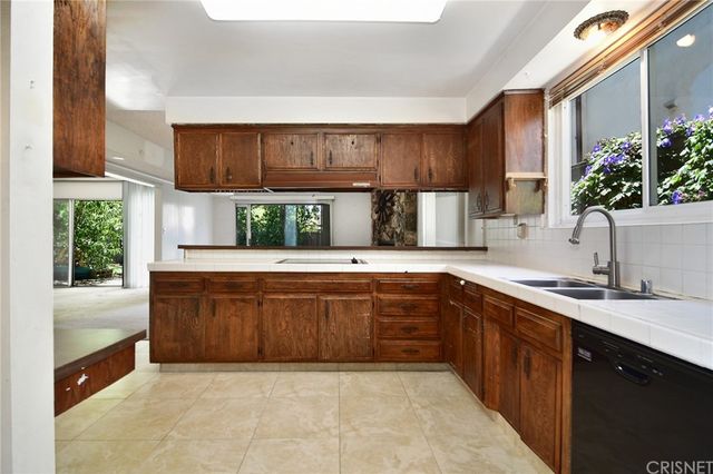 a large kitchen with kitchen island granite countertop a sink stainless steel appliances and cabinets