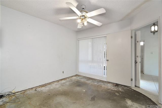 an empty room with fan and entrance