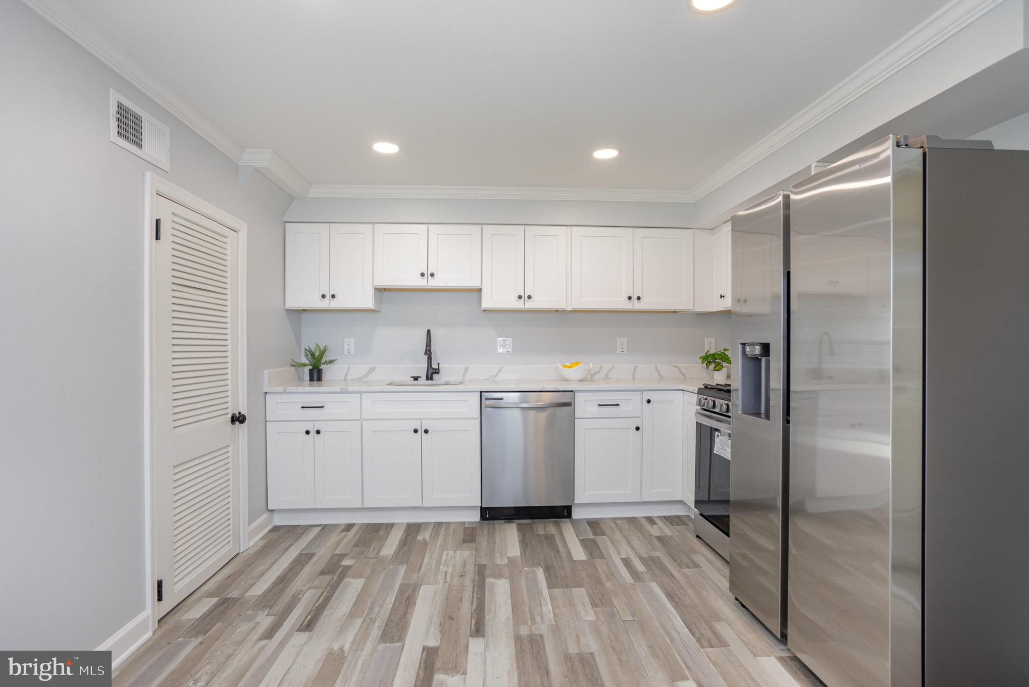 2070 Larkhall Road Dundalk, MD 21222 - Photo 8 of 26 a kitchen with a refrigerator a sink and cabinets