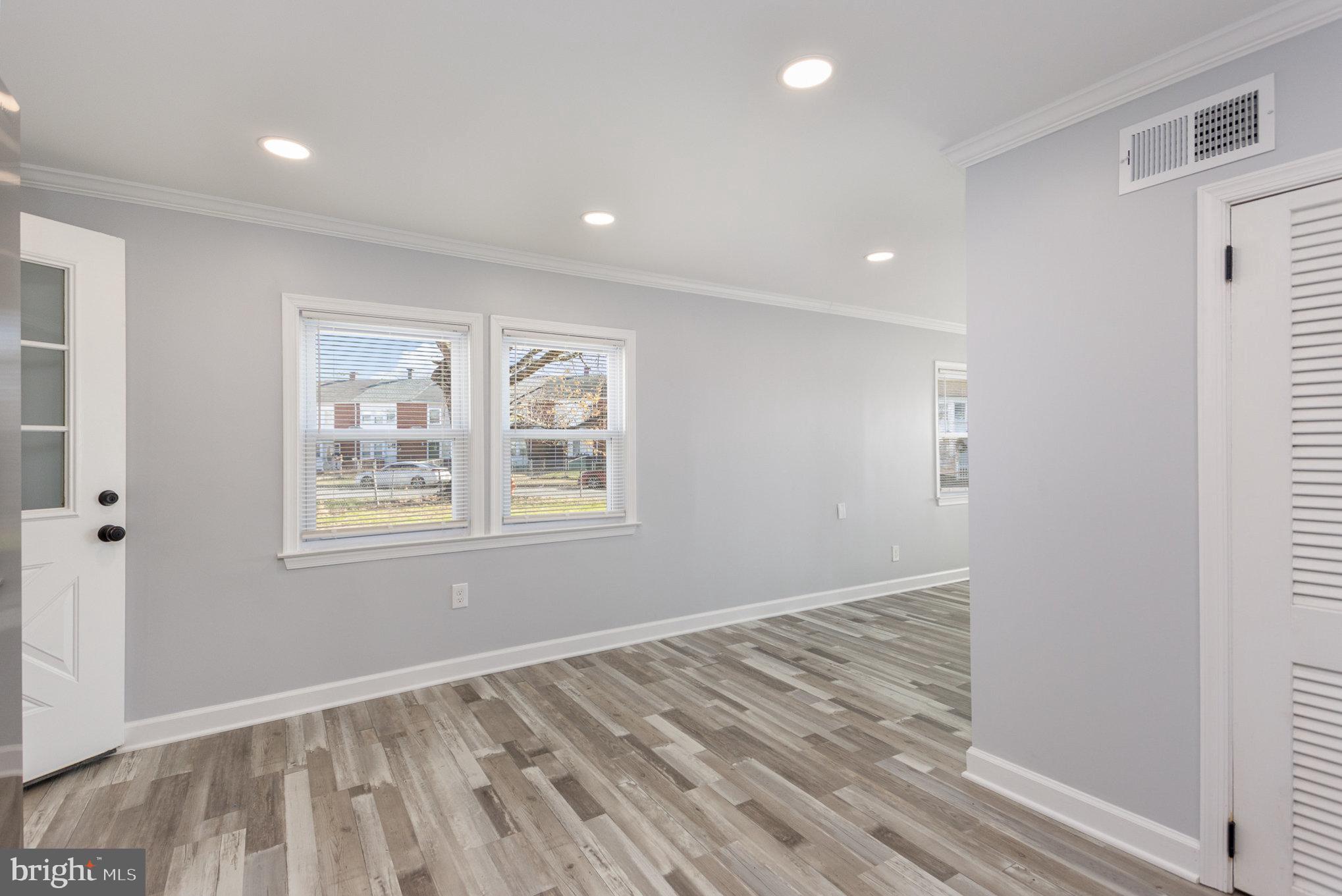 2070 Larkhall Road Dundalk, MD 21222 - Photo 6 of 26 a view of an empty room with wooden floor and a window