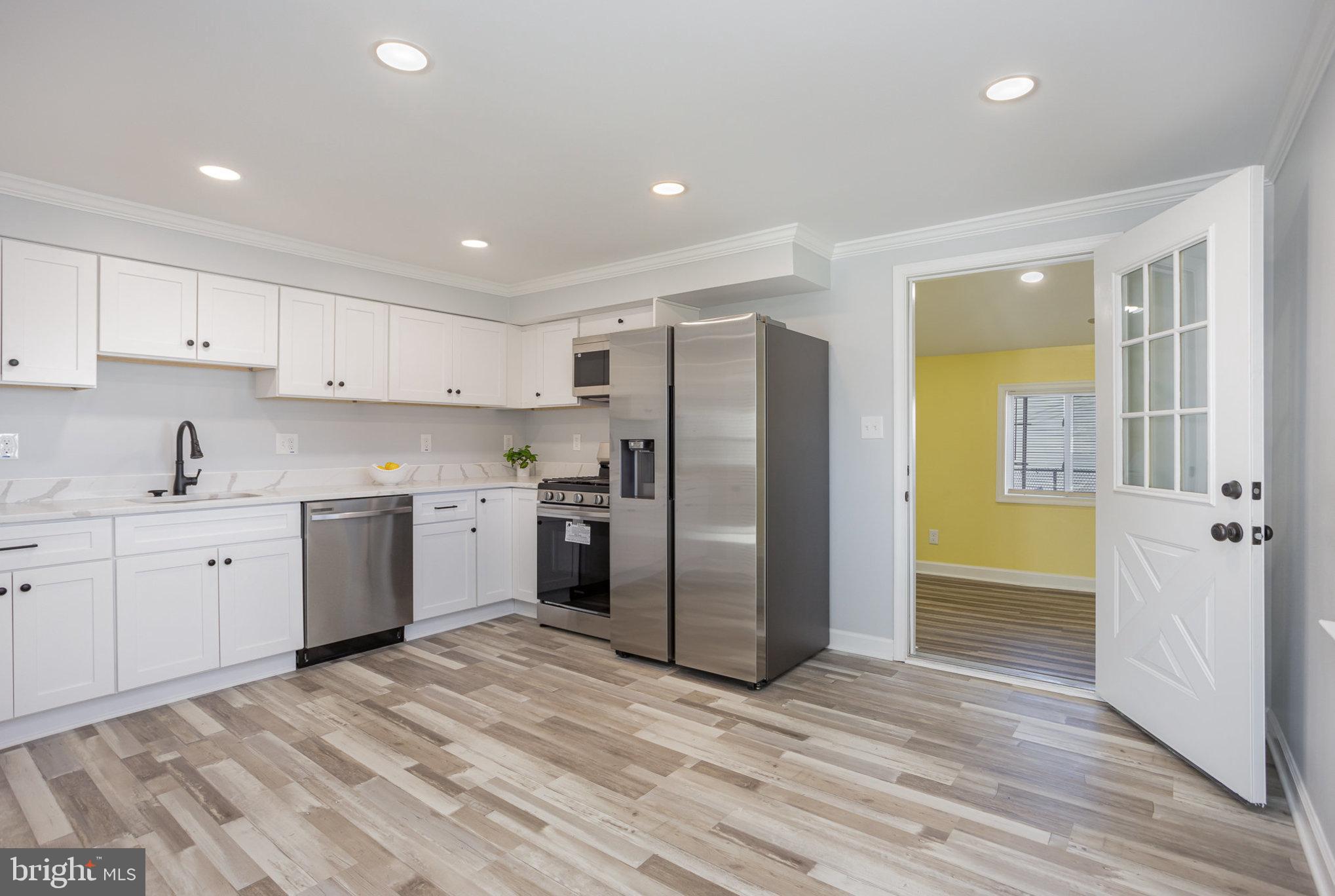 2070 Larkhall Road Dundalk, MD 21222 - Photo 7 of 26 a kitchen with a refrigerator sink and cabinets