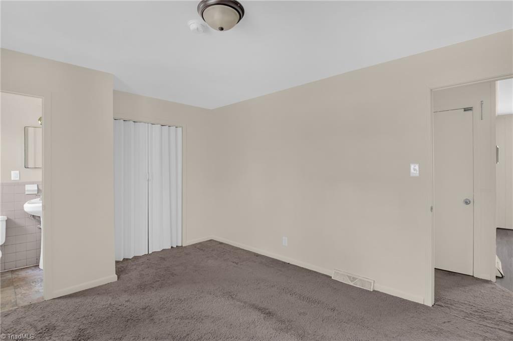 8225 Easley Road Walnut Cove, NC 27052 - Photo 18 of 33 Primary bedroom showing closet area and half bath to the left.