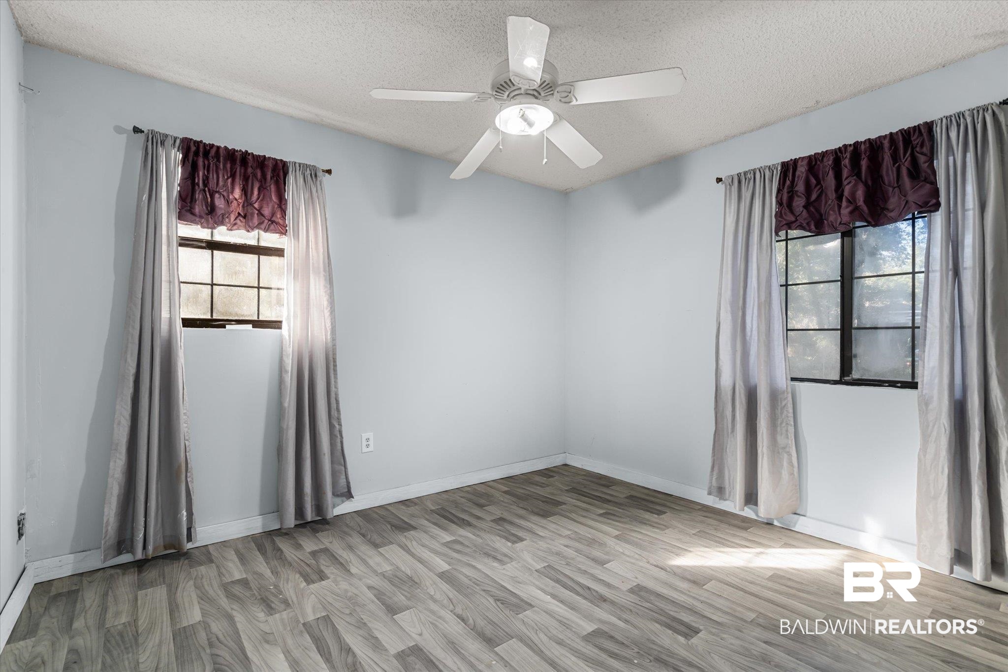 6233 Ponder Road Fairhope, AL 36532 - Photo 9 of 20 Spare room with ceiling fan, light wood-type flooring, and a textured ceiling
