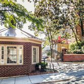 a front view of a house with a tree