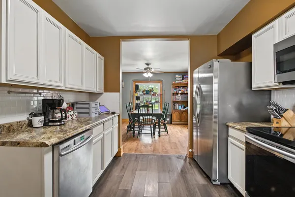 a kitchen with stainless steel appliances granite countertop a stove a sink and a microwave