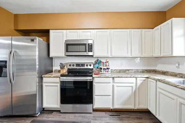 a kitchen with a sink cabinets and wooden floor
