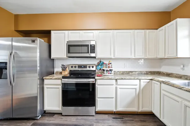a kitchen with a sink cabinets and wooden floor