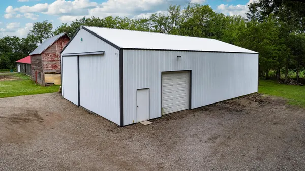 a view of a small house with a yard and garage