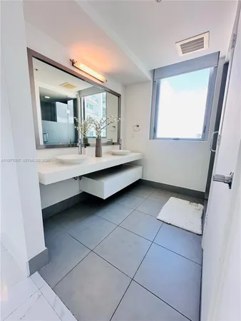 a bathroom with a double vanity sink mirror and toilet