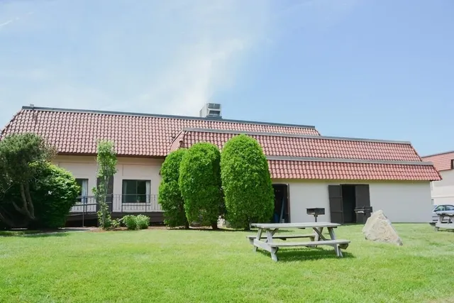 a view of a patio with a table and chairs under an umbrella