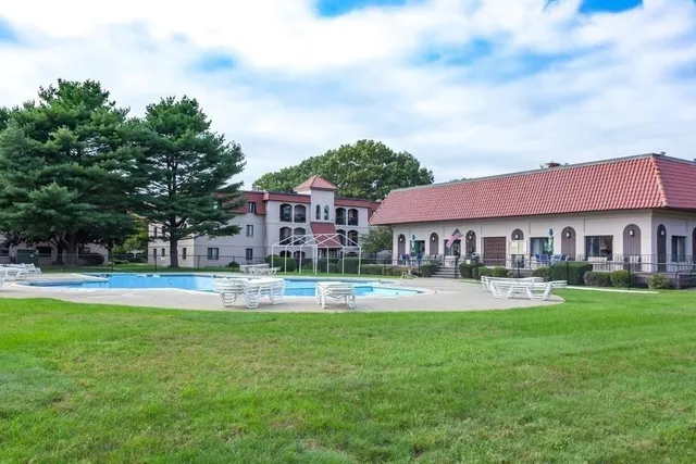 a front view of a house with swimming pool and garden
