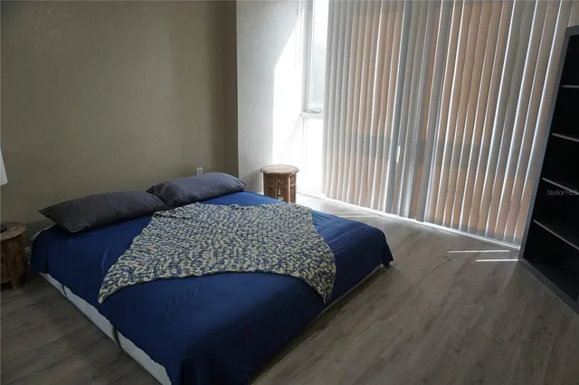 a bedroom with a bed lamp and a large window