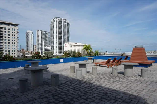 a view of a patio with table and chairs under an umbrella with a table and chairs