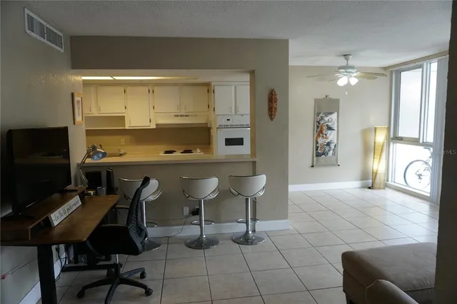 a living room with furniture a flat screen tv and kitchen view