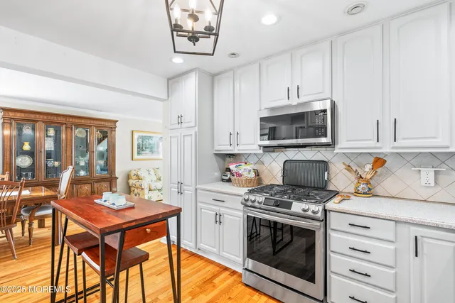 a kitchen with stainless steel appliances a stove a sink and cabinets