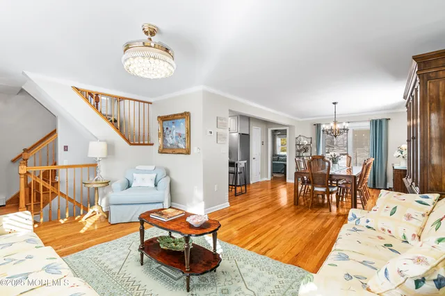 a living room with furniture a dining table and chairs with wooden floor
