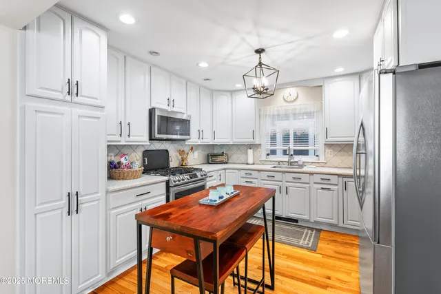 a kitchen with kitchen island granite countertop stainless steel appliances cabinets a sink and a counter top space