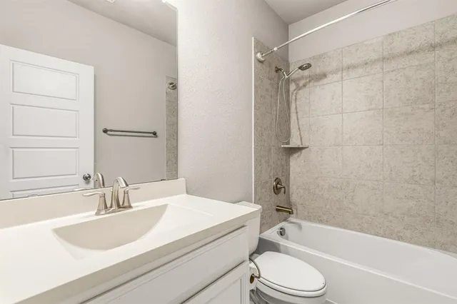 a bathroom with a granite countertop sink toilet bathtub and shower