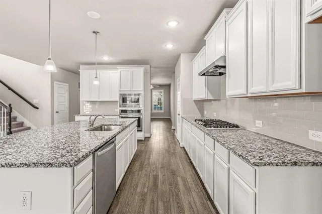 a large kitchen with kitchen island granite countertop a large center island attached withe stove top oven