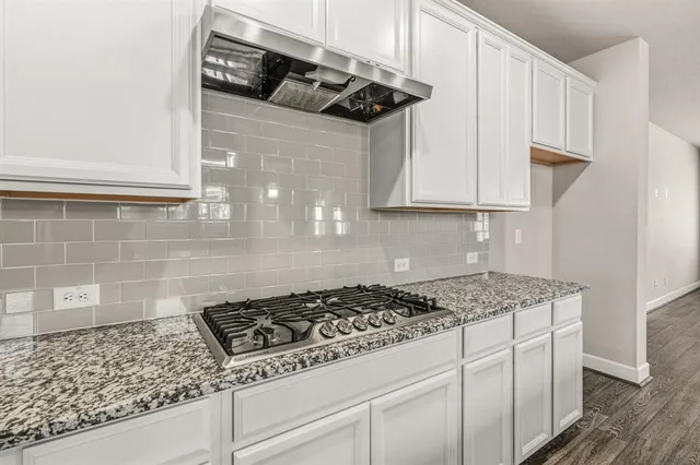 a kitchen with stainless steel appliances granite countertop a sink stove and cabinets