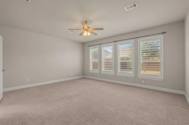 an empty room with a window and a ceiling fan