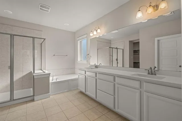 a spacious bathroom with a double vanity sink a mirror and a bathtub
