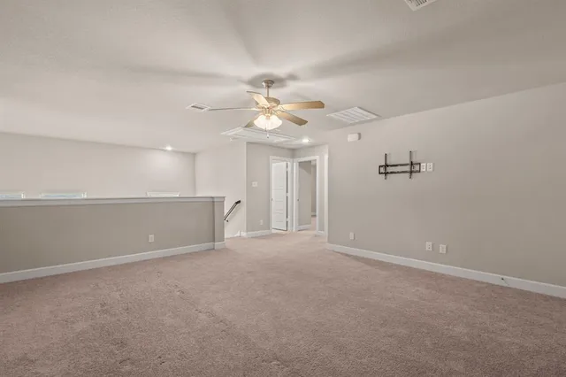 a view of an empty room with a ceiling fan