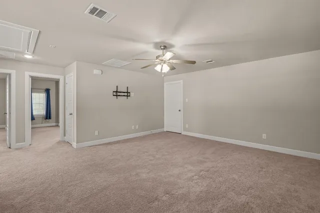 an empty room with a ceiling fan and a window