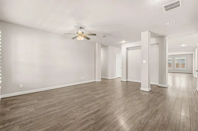 a view of a livingroom with wooden floor and a ceiling fan