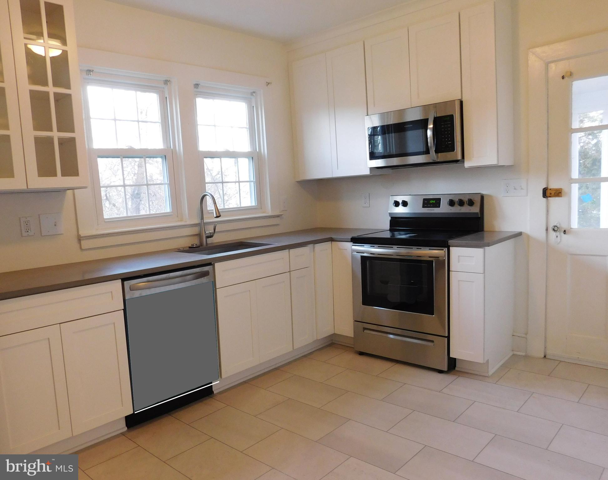 641 Old Meetze Road Warrenton, VA 20186 - Photo 6 of 15 a kitchen with stainless steel appliances granite countertop white cabinets a sink a stove a microwave and a window