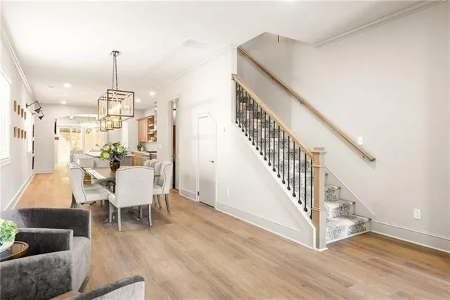 a view of a dining room with furniture a chandelier and wooden floor