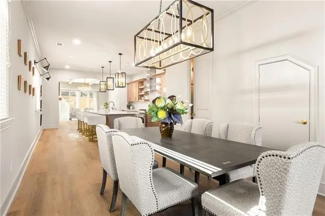 a dining room with furniture potted plants and wooden floor
