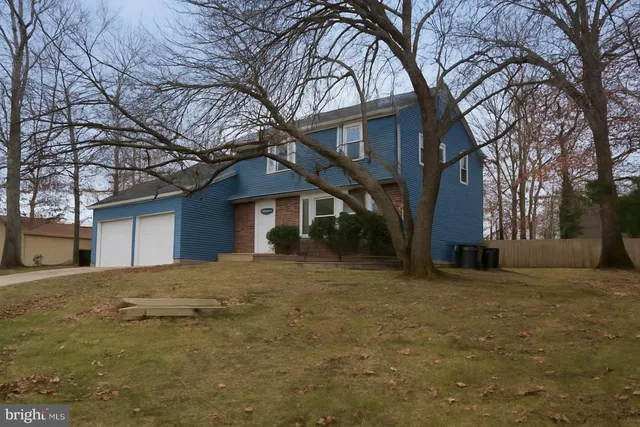 a yellow house with trees in front of it