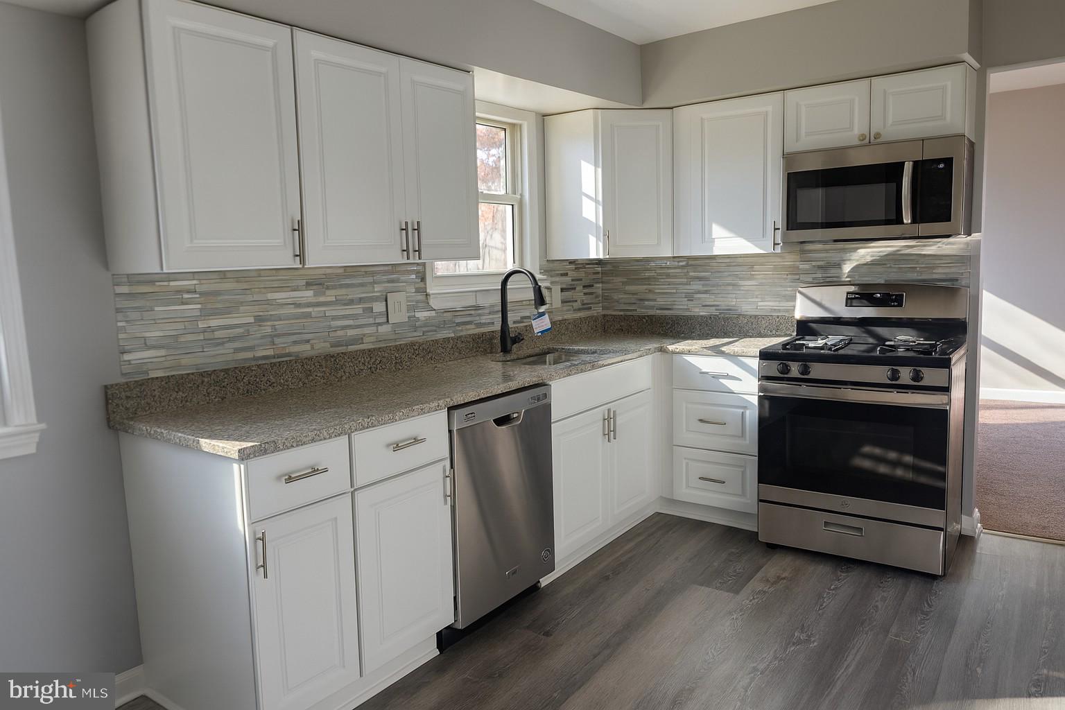 112 Hemlock Drive Williamstown, NJ 08094 - Photo 4 of 12 a kitchen with stainless steel appliances white cabinets and a stove top oven