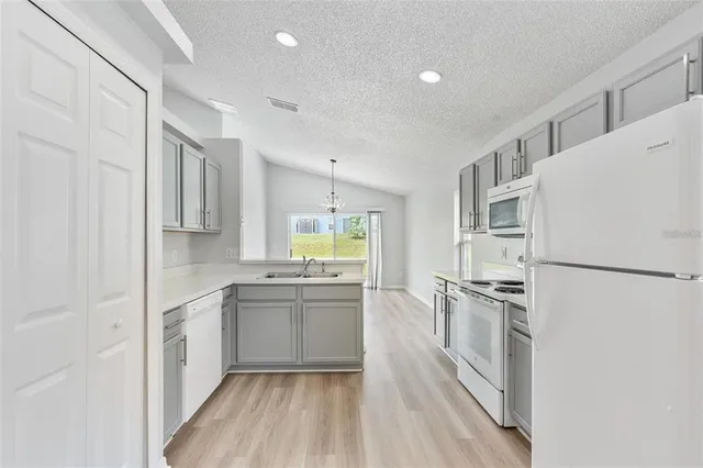 a kitchen with white cabinets and white appliances