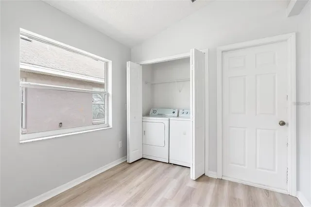 a view of an empty room with closet and a window