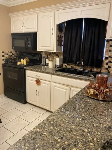 a kitchen with stainless steel appliances a stove a microwave a sink and cabinets
