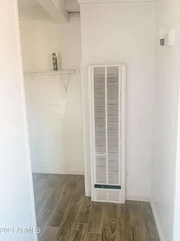 a view of a closet area with wooden floor