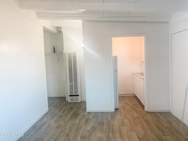 an empty room with wooden floor and a sink
