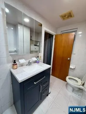 a bathroom with a sink a toilet and a mirror