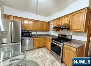 a kitchen with stainless steel appliances granite countertop a stove a sink dishwasher a refrigerator and cabinets with wooden floor