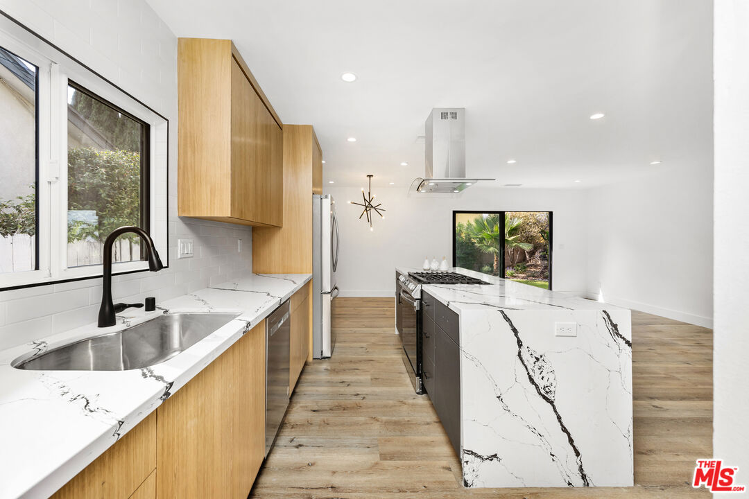5627 Agnes Avenue Valley Village, CA 91607 - Photo 3 of 11 a kitchen with a sink a counter top space stainless steel appliances and a large window