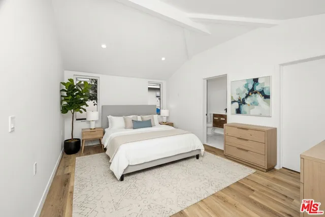 a spacious bedroom with a bed and a potted plant