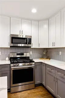 a kitchen with cabinets stainless steel appliances and a sink