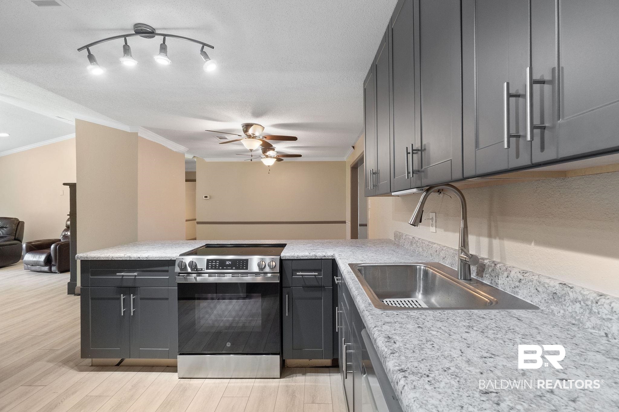 27300 C R Watson Road Robertsdale, AL 36567 - Photo 10 of 35 Kitchen with stainless steel appliances, sink, light hardwood / wood-style floors, crown molding, and a textured ceiling