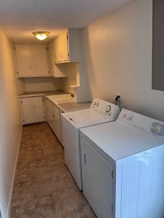 a utility room with cabinets washer and dryer