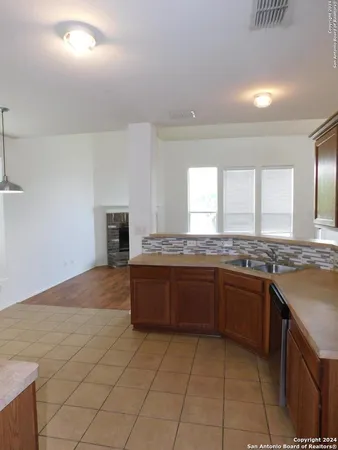 a large kitchen with granite countertop a stove a sink and a microwave