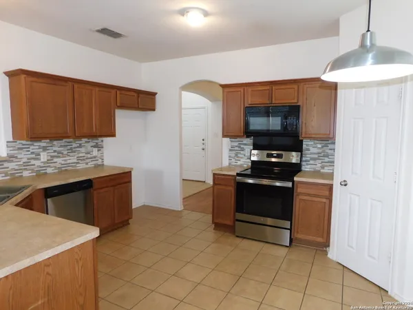a kitchen with stainless steel appliances a stove a sink a microwave and a refrigerator