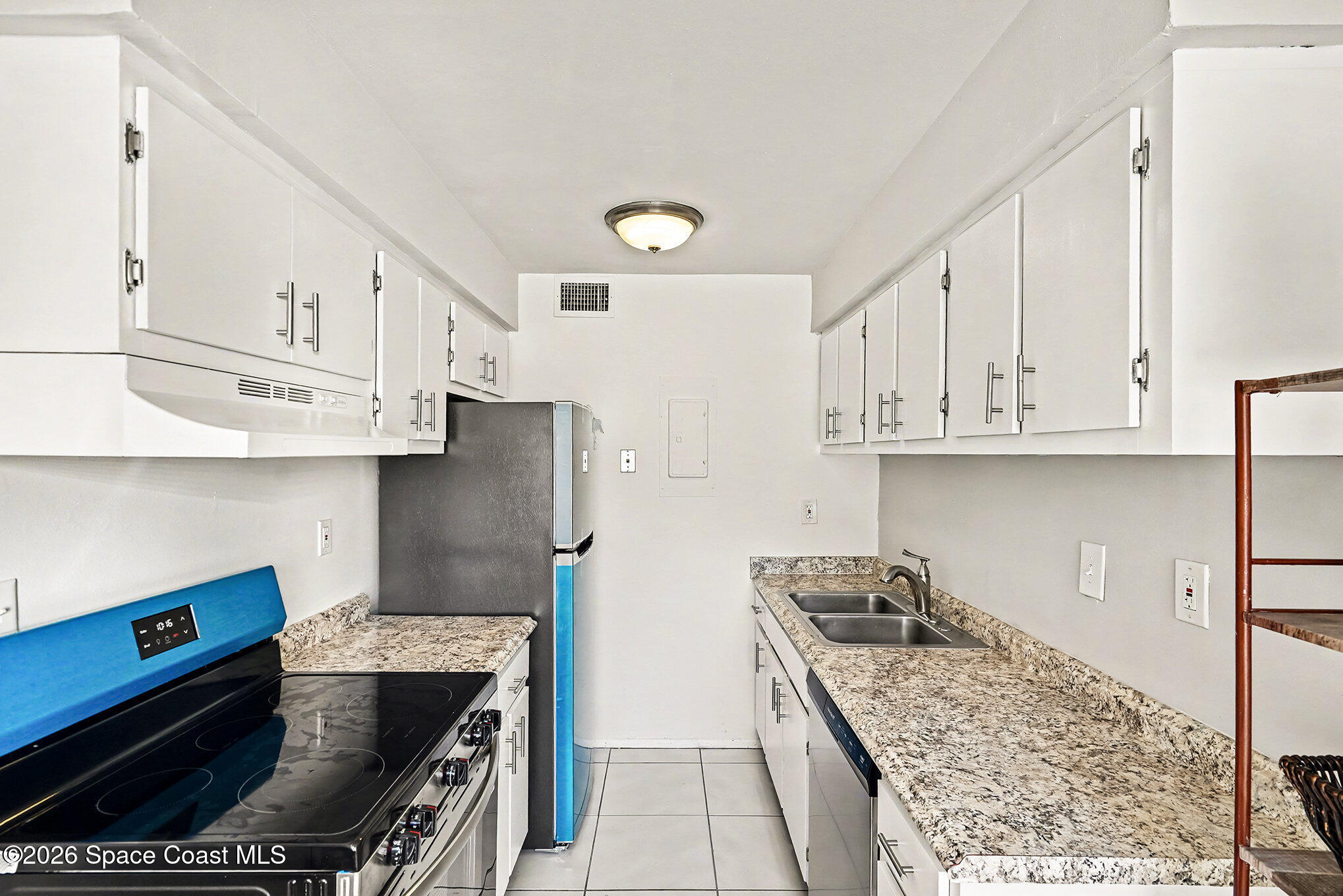 1225 North Wickham Road, Unit 411 Melbourne, FL 32935 - Photo 14 of 26 a kitchen with stainless steel appliances granite countertop a stove a refrigerator and a sink
